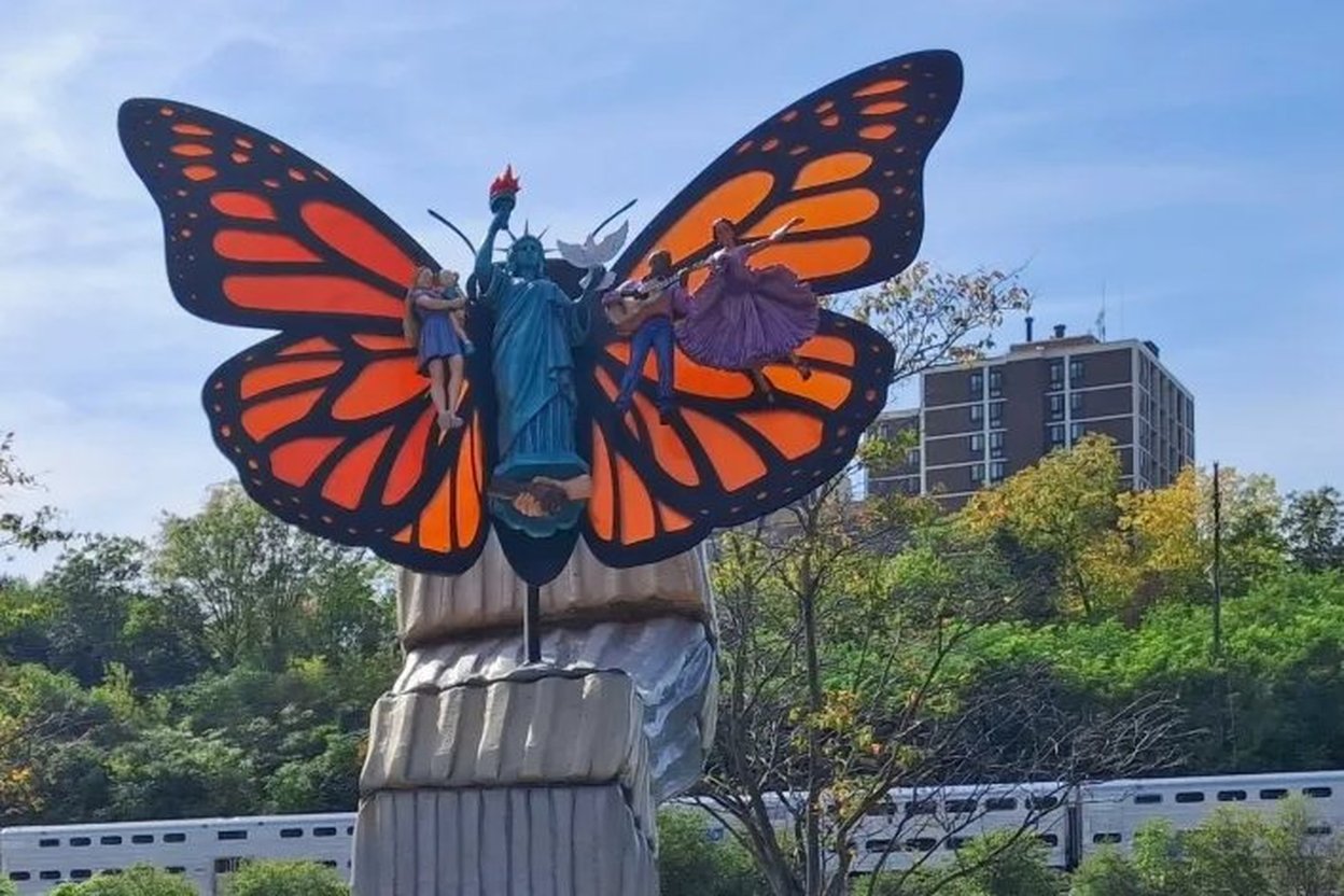Elgin's Pursuit of Happiness sculpture: a Statue of Liberty figure with monarch butterfly wings and children on the wings.