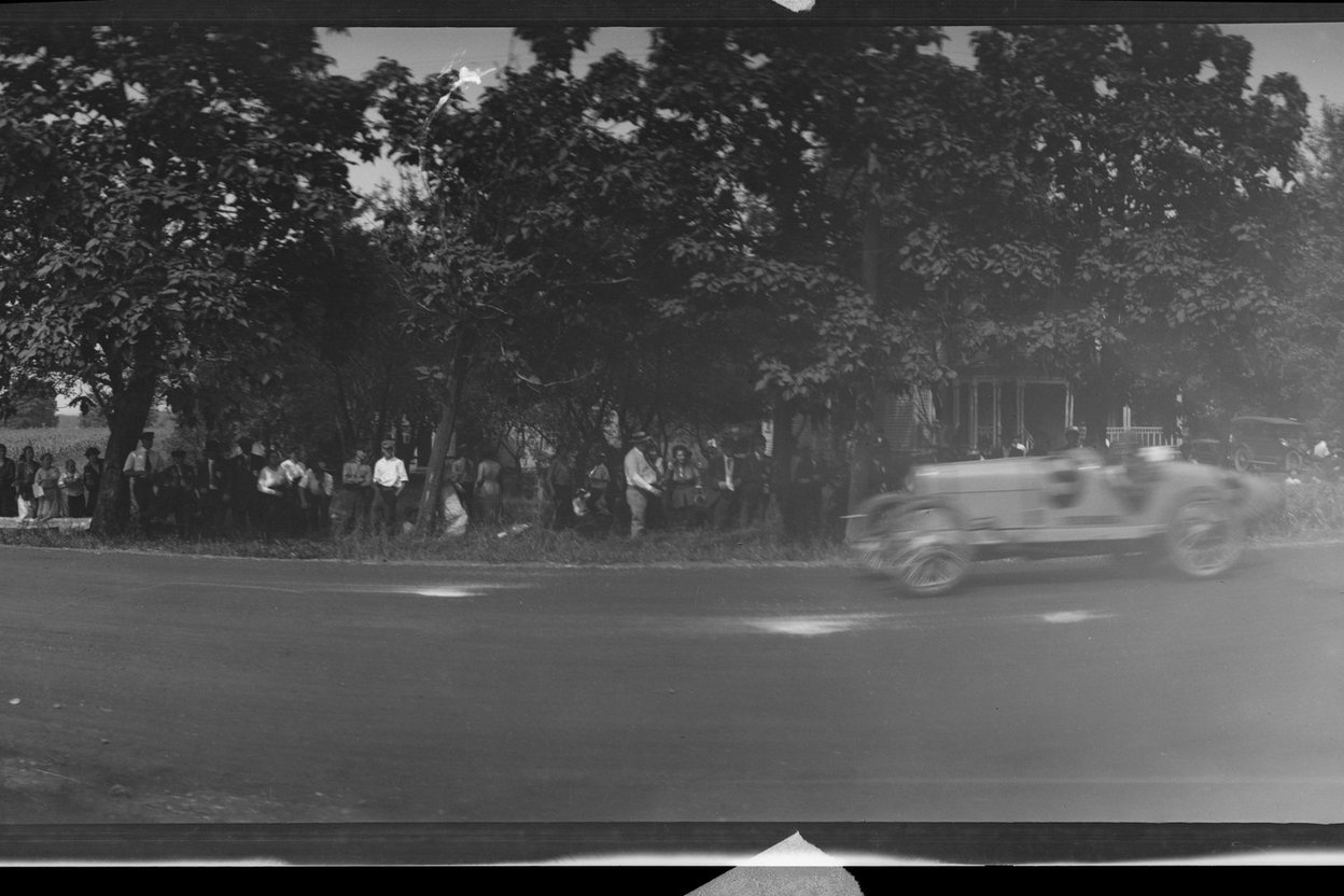 An early 1900s race car on a dirt road at the Elgin Road Races