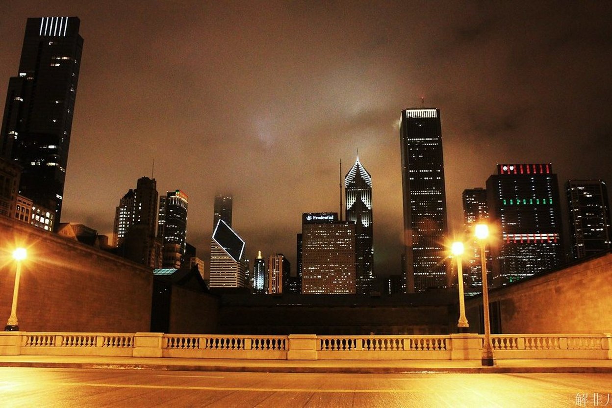 Chicago skyline at night with illuminated skyscrapers and streetlights.